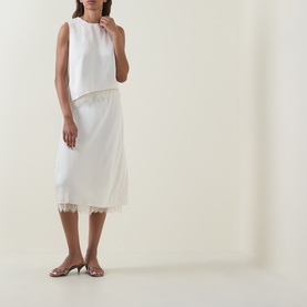 Model wearing Vince Asymmetric Lace Trim Top in cream satin with floral lace hem, styled with a matching midi skirt and silver mules.