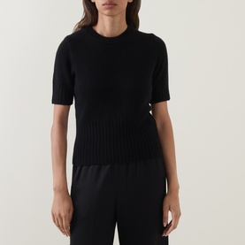 Model wearing Vince black wool-cashmere blend short-sleeve ribbed knit top, styled with black wide-leg trousers.