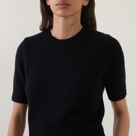 Model wearing Vince black wool-cashmere blend short-sleeve knit top with ribbed hem and crew neckline.