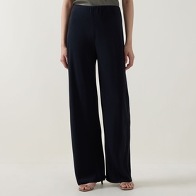 Model wearing Vince navy wide-leg trousers in fluid fabric, styled with strappy heeled sandals.