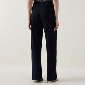 Model wearing Vince navy wide-leg trousers, rear view, with a light-coloured top visible at waist.