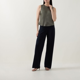 Model wearing Vince pine grove sleeveless top in relaxed silhouette, styled with wide-leg black trousers and metallic heels.