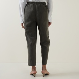 Model wearing Vince trousers in Sea Vine, elasticated waist, tapered leg, back view, styled with a white shirt and nude heels.
