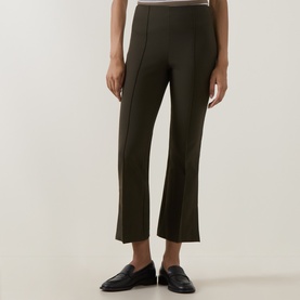 Model wearing Vince khaki trousers with front seam detail and cropped flare hem, styled with black loafers