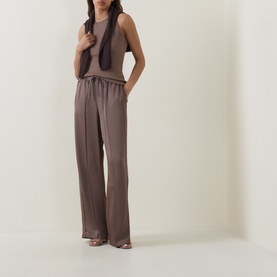 Model wearing Vince taupe haze wide-leg trousers with drawstring waist, styled with matching sleeveless top and strappy heels.