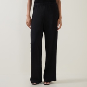 Model wearing Vince black wide-leg trousers with elasticated waist, styled with black heeled sandals