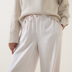 Model wearing Vince Blush Cloud trousers with elasticated drawstring waist, styled with a cream knit sweater
