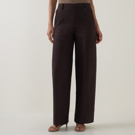 Model wearing Vince Pleated Straight-Leg Trousers in brown, mid-rise with pressed pleats and wide leg, styled with nude heels.