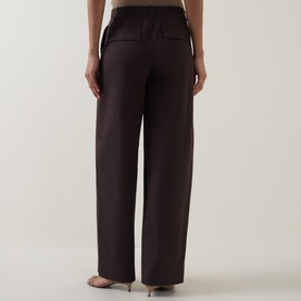 Model wearing Vince Pleated Straight-Leg Trousers in brown, showing rear view with flap pockets and straight-leg silhouette, styled with nude heels.