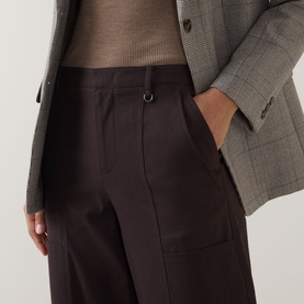 Model wearing Vince Pleated Straight-Leg Trousers in brown with D-ring detail and side pockets, styled with a grey check blazer.