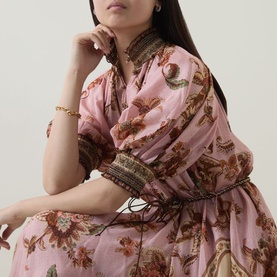 Model wearing Zimmermann dress in Mauve Jacobean floral print, with puff sleeves, embroidered trim, and tie waist detail