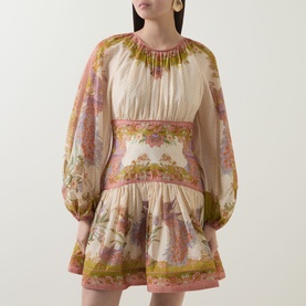 Model wearing Zimmermann dress in Chartreuse Scarf Floral, balloon sleeves, gathered neckline, drop-waist mini length with flared skirt.