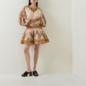 Model wearing Zimmermann dress in Chartreuse Scarf Floral, featuring puffed sleeves and tiered mini skirt, styled with dark brown block-heel mules.