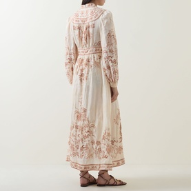 Model wearing Zimmermann Indra Linen Plunge Dress in Cream Tan Floral, midi length with billowy sleeves and fitted waistband, styled with tan sandals.