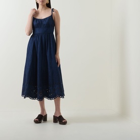 Model wearing Zimmermann ink dress with broderie anglaise hem, adjustable tie straps and gathered waist, styled with brown block-heel mules