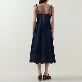 Model wearing Zimmermann dress in ink, back view, with tie shoulder straps, broderie anglaise hem, styled with tan mule sandals