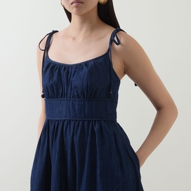 Model wearing Zimmermann dress in ink, featuring tie shoulder straps, gathered bodice, and elasticated waist detail.