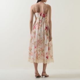 Model wearing cream floral midi dress with thin straps and lace hem trim, styled with tan strappy heeled sandals, back view