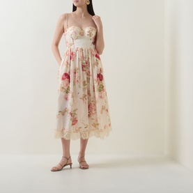Model wearing floral midi dress with bustier bodice, lace hem trim, and gathered skirt, styled with strappy heeled sandals