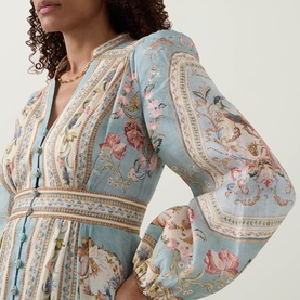 Model wearing Zimmermann Roselight Tapestry Floral Dress in Blue Tapestry Floral, showing plunging V-neckline, stone buttons and billowing sleeves