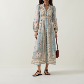 Model wearing Zimmermann Roselight Tapestry Floral Dress in Blue Tapestry Floral, midi length with billowed sleeves, styled with brown bag and black