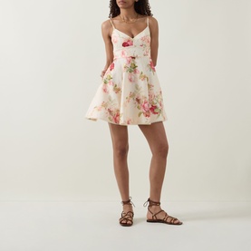 Model wearing Zimmermann Roselight Rose Floral Mini Dress in cream with pink floral print, flared skirt, and thin straps, styled with brown lace-up