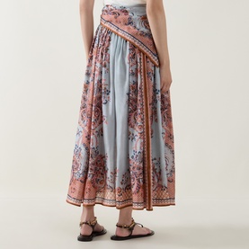 Model wearing Zimmermann Blue Paisley Floral silk midi skirt with gathered waist and contrast border print, styled with flat brown sandals.