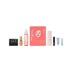 Arnotts Jet Setters Edit beauty gift set box surrounded by skincare, makeup, and beauty products on a blue background.