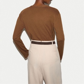 Model wearing Jigsaw brown long-sleeve top, back view, styled with cream pinstripe trousers and brown belt.