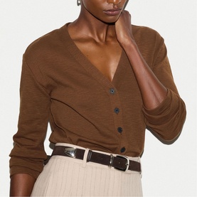 Model wearing Jigsaw brown V-neck button-front cardigan, styled with a cream pleated skirt and brown leather belt.
