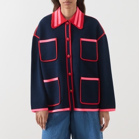 Model wearing Essentiel Antwerp navy cardigan with pink contrast trim, patch pockets, and button front, styled with light blue jeans.