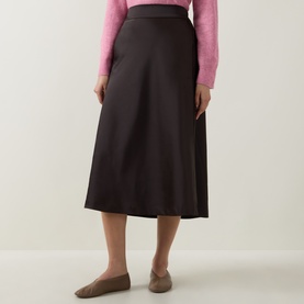 Model wearing InWear Chocolate Brown midi skirt in A-line silhouette, styled with a pink knit top and taupe loafers.