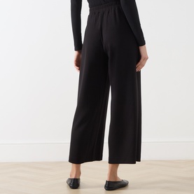 Model wearing InWear black wide-leg cropped trousers with elasticated waist, styled with a black long-sleeve top and black flats.