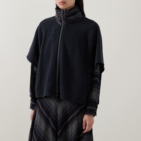 Model wearing Luisa Cerano anthracite knit zip-up jacket with high neck, styled with a pleated chevron skirt