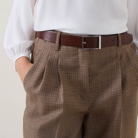Model wearing Luisa Cerano multi hound's-tooth check wide-leg trousers with brown leather belt and white blouse.