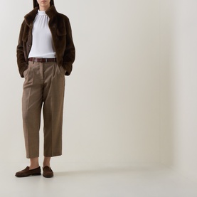 Model wearing Luisa Cerano multi taupe wide-leg trousers with brown belt, styled with white top, brown shearling jacket and loafers.
