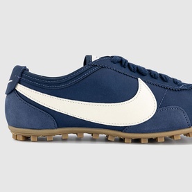 Nike Midnight Navy and Soft Pearl trainer with large white Swoosh, navy lace-up upper, and gum rubber sole