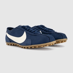 Nike Cortez trainers in Midnight Navy and Soft Pearl, featuring large white swoosh, nubuck upper, and tan gum rubber outsole