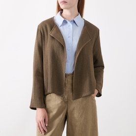 Model wearing Masai Slate Black cardigan with open front, styled with light blue shirt and tan wide-leg trousers