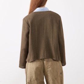 Model wearing Masai Slate Black cardigan, back view, styled with light blue collar and beige trousers