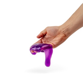 Hand stretching purple Nee Doh Lava Instant Slime, showing glossy texture and dripping consistency from the fidget toy three-pack