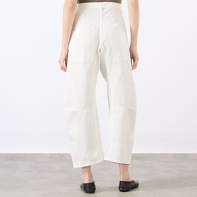 Model wearing Nili Lotan Vintage Cream wide-leg trousers, back view, styled with black flat loafers.