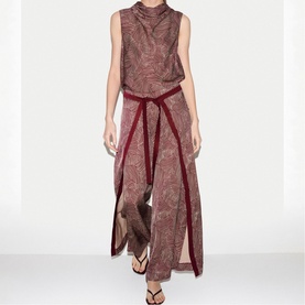 Model wearing Jigsaw red paisley print sleeveless maxi dress with contrast burgundy trim tie waist, styled with black sandals