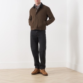 Model wearing Paige Pinecone casual jacket in brown cotton, styled with checked shirt, dark trousers and tan leather shoes.