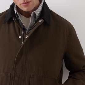Model wearing Paige Pinecone casual jacket in cotton, with contrast dark collar, snap fastening, layered over striped shirt
