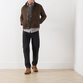 Model wearing Paige Pinecone casual jacket in brown cotton, styled with grey shirt, black jeans and tan suede boots.