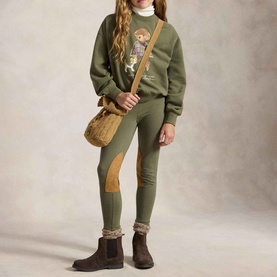 Model wearing Ralph Lauren Polo Bear Logo Fleece Sweatshirt in Cruise Olive, styled with matching olive leggings and brown ankle boots.