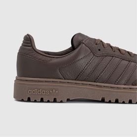 Adidas brown leather trainer with tonal three-stripe detailing, lace-up front, and matching brown chunky rubber sole