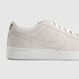 Nike trainer in sail white suede with perforated Swoosh logo detail and white sole, close-up heel and side view