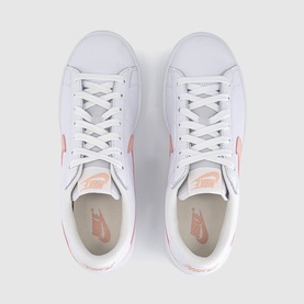 Nike trainers in white with arctic orange Swoosh logo, white laces and light beige insole, overhead flat-lay view
